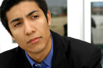 A mixed race man looks to the middle distance with a thoughtful expression.